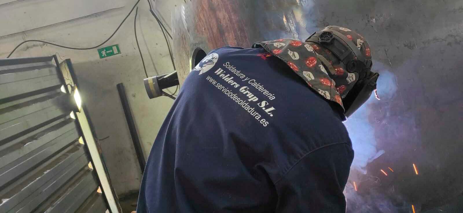 Soldador trabajando en obra industrial